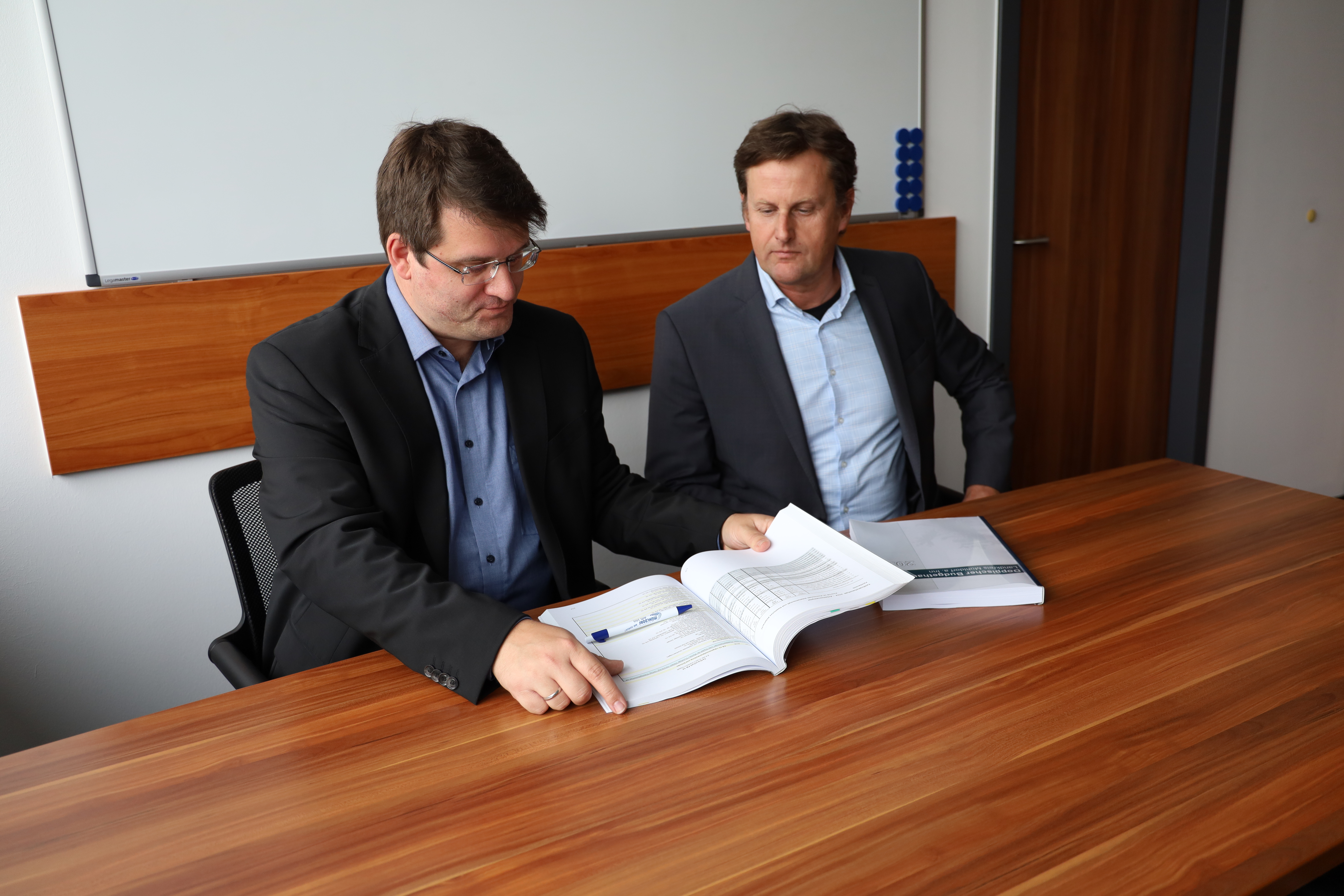Geschäftsbereichsleiter Patrick Schumann und Landkreiskämmerer Markus Heiml mit dem Haushalt für 2024